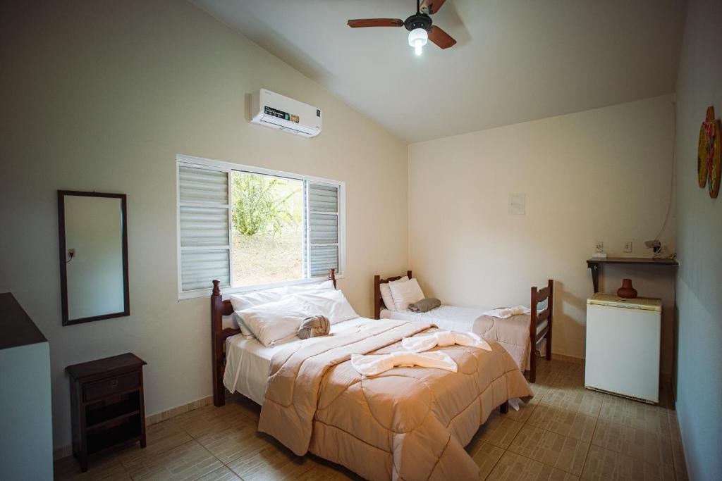 een slaapkamer met een bed en een raam bij Pousada Horizonte da Canastra in São Roque de Minas