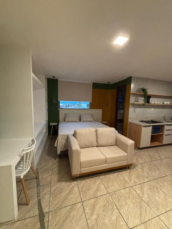 een slaapkamer met een bed en een bank erin bij Flat com vista mar in Mucuri