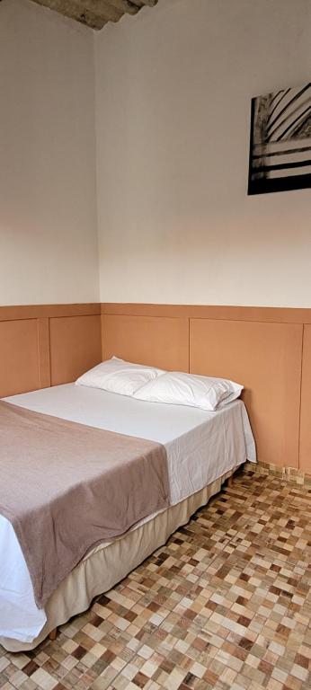 a large bed in a room with a tiled floor at Do Alto da Montanha Pousada in Vale do Capao