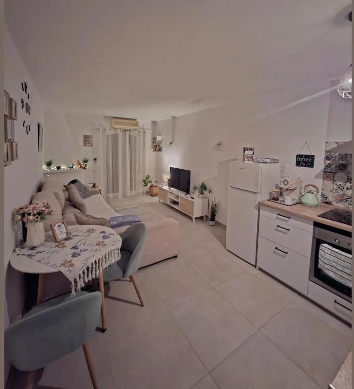 a kitchen and living room with a couch and a table at CASA PERSEA in Nerja