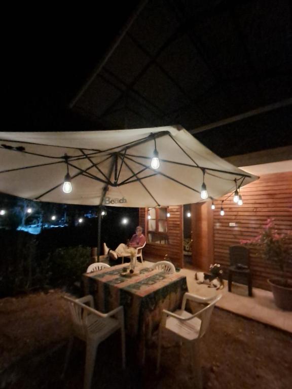 un tavolo e sedie sotto un ombrellone di notte di Cabaña BellaVista a Oxapampa