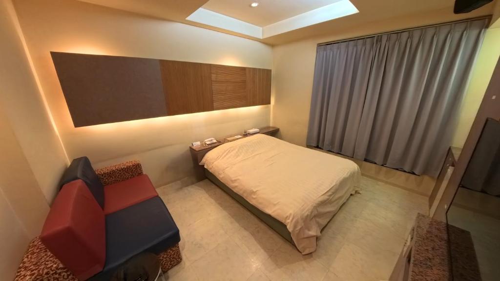 a small bedroom with a bed and a couch at ヴァンヴェールアネックス in Kyoto