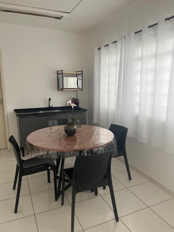 tavolo da pranzo con sedie nere e lavandino di Pousada Sete Colinas a Bragança Paulista