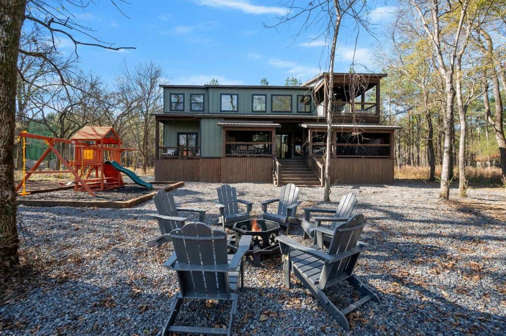 a house with chairs and a playground in front of it at Chillax Inn The River For 19 in Broken Bow
