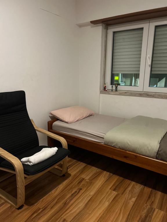 a bedroom with a bed and a chair and a window at MALÔ - Queluz in Queluz