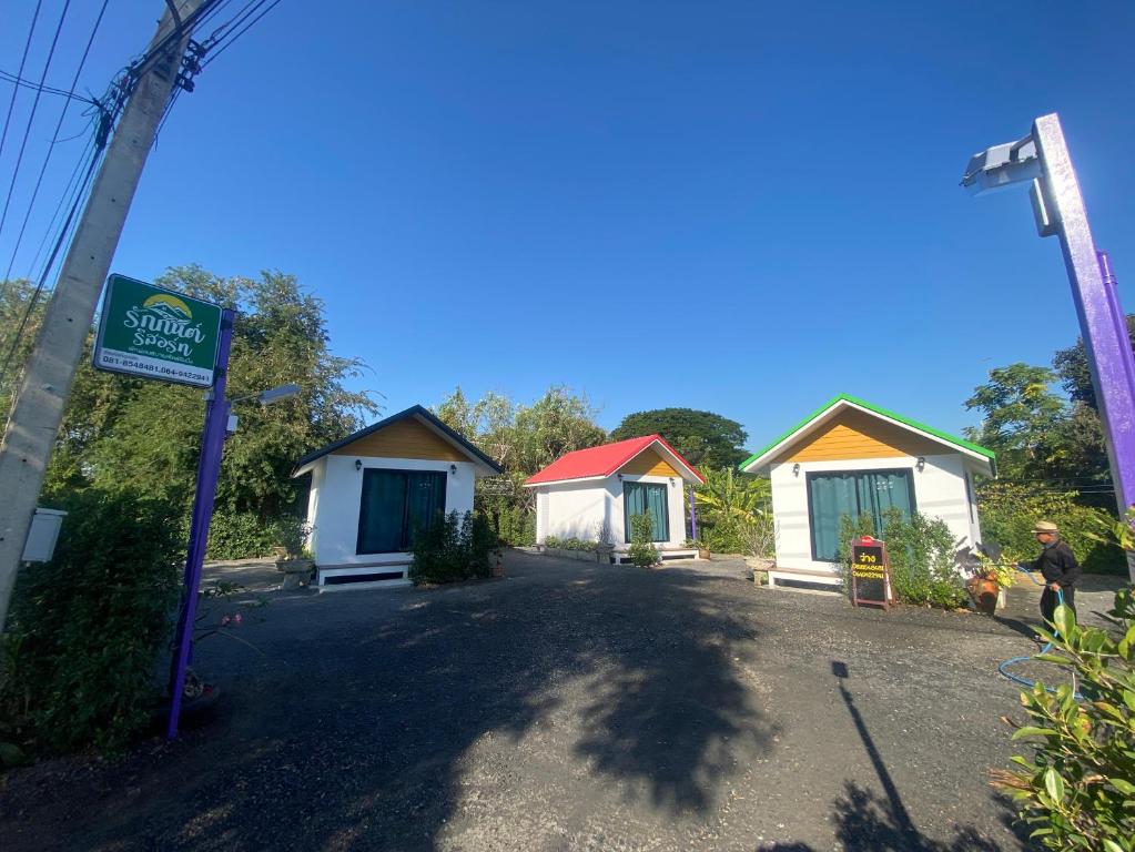 a row of small cottages with a sign in front at รักกันต์ รีสอร์ท in Ban Sakat Namman