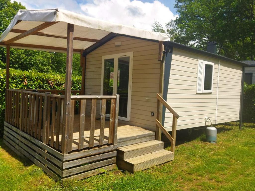 eine Hütte mit einer Terrasse und einem Pavillon in der Unterkunft Mobil-home confortable avec terrasse à Saint-Gérons - API-1-52-1311 in Saint-Étienne-Cantalès