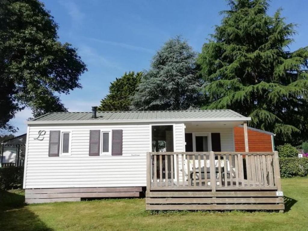 a small white tiny house with a porch at Mobil-home confortable avec terrasse à La Couarde - API-1-52-1305 in Saint-Nicolas des Eaux