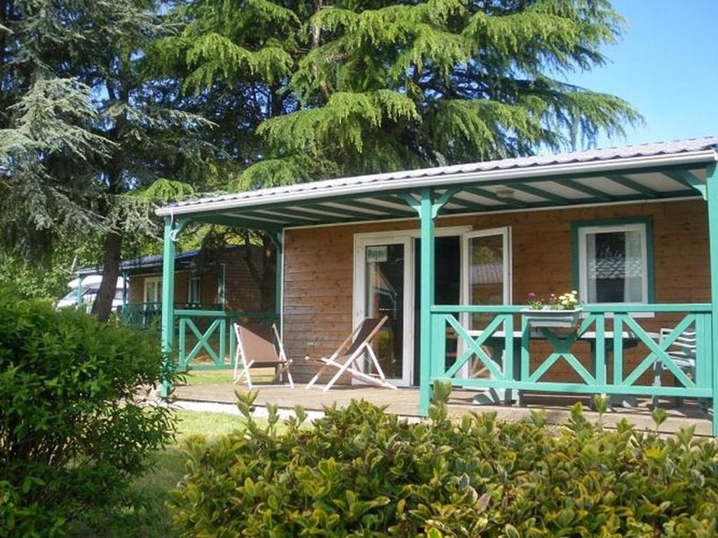 een huis met een veranda met een tafel en stoelen bij Chalet avec Terrasse pour 4 Pers. - API-1-52-1306 in Saint-Nicolas