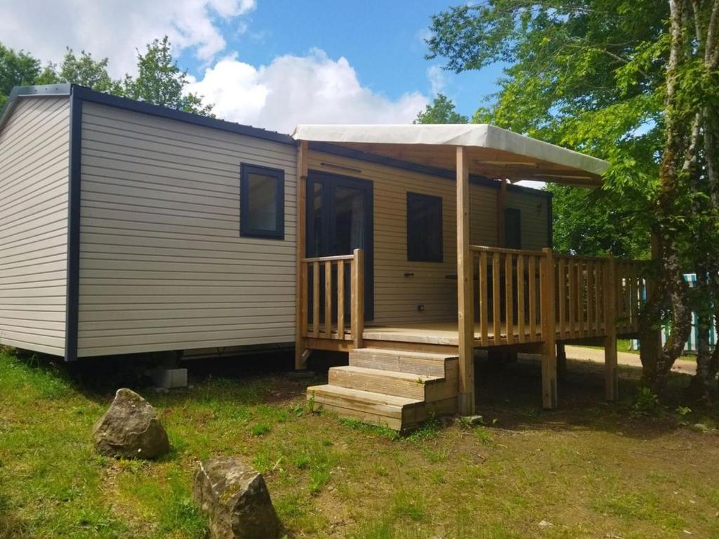 ein kleines Haus mit einer Veranda und einer Terrasse in der Unterkunft Mobil-home 35m² avec Terrasse - Saint-Gérons - API-1-52-1314 in Saint-Étienne-Cantalès