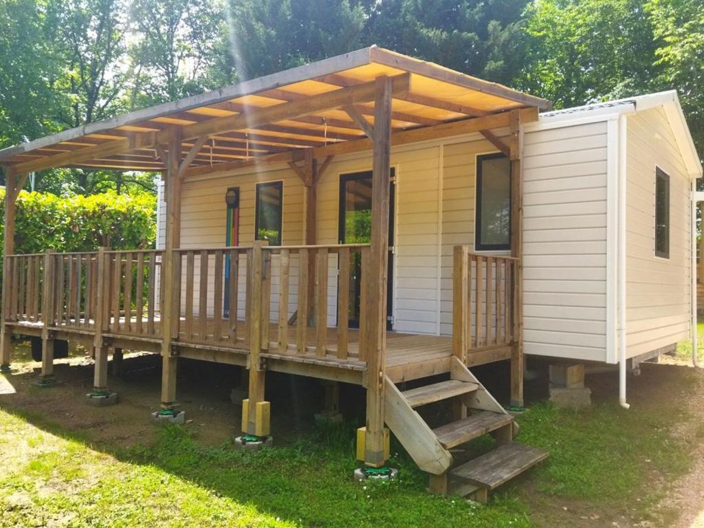 ein kleines Haus mit einer Veranda und einer Terrasse in der Unterkunft Mobil-home 27m² à Saint-Gérons avec terrasse - API-1-52-1316 in Saint-Étienne-Cantalès