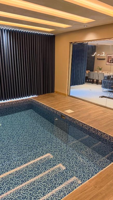een zwembad in een kamer met een woonkamer bij شاليهات لورين الفندقية in Taif