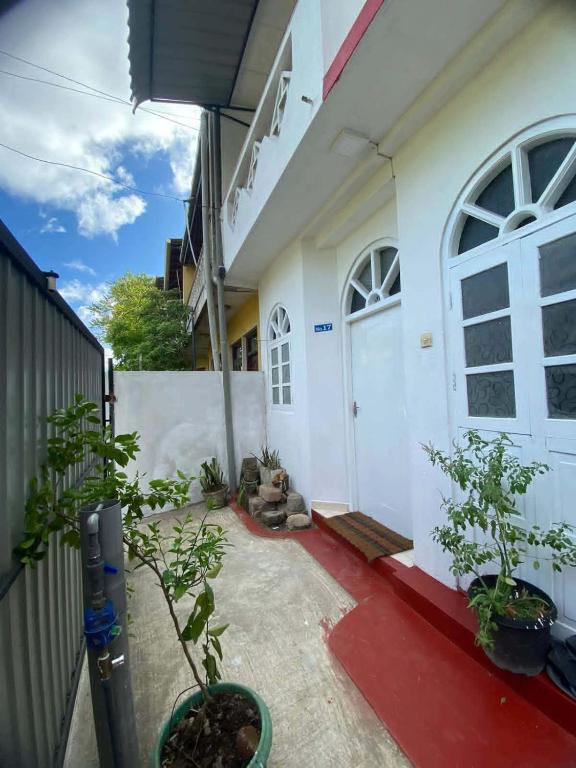 a house with a white door and some plants at Apartment no17 in Galle