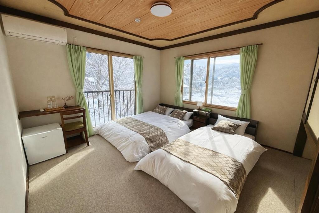 een slaapkamer met twee bedden en een raam bij 雪场缆车站旁-START HOUSE PIAA-Ski IN Ski OUT in Minami Uonuma