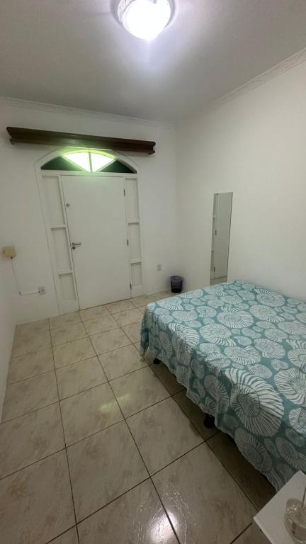 Schlafzimmer mit einem Bett, einem Fenster und einer Tür in der Unterkunft Pousada próximo ao hospital regional in São José