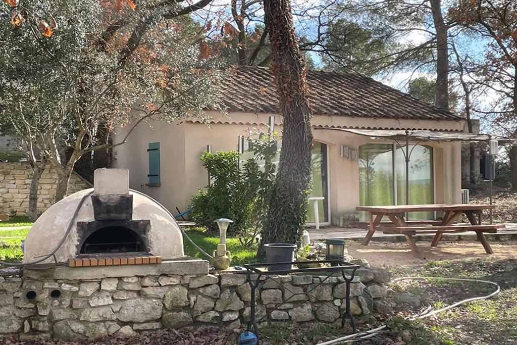 un forno in pietra in un cortile con tavolo da picnic di Gîte du Jonquas a Velleron