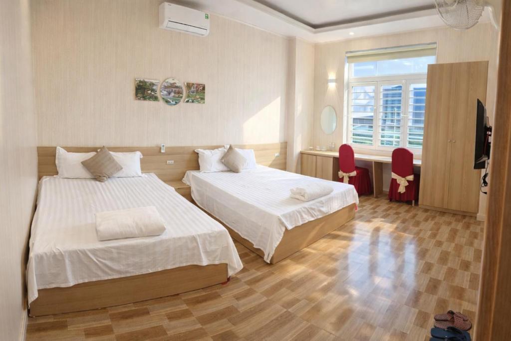 een hotelkamer met twee bedden en een raam bij Hưng Phát Hotel - Gần Bến Xe Hà Tĩnh in Ha Tinh