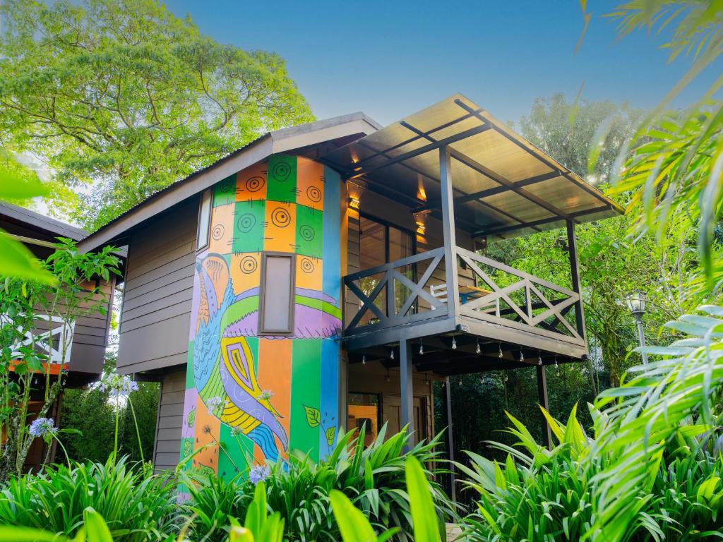 een huis met een kleurrijke muurschildering op de voorgevel bij Nido de Montaña in Alajuela