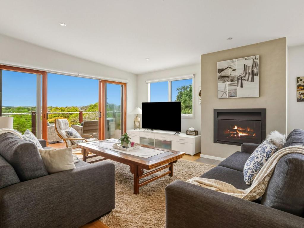 een woonkamer met twee banken en een open haard bij Olive Tree Retreat in Tootgarook