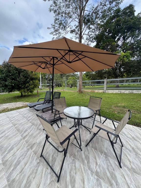 un tavolo e sedie sotto un grande ombrellone di Villa en la naturaleza 