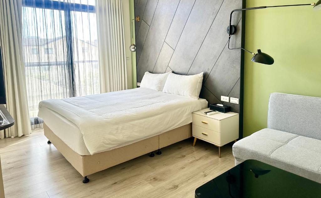 北緯23點5度民宿-車位可預訂 في مدينة هوالين: غرفة نوم صغيرة بها سرير وكرسي