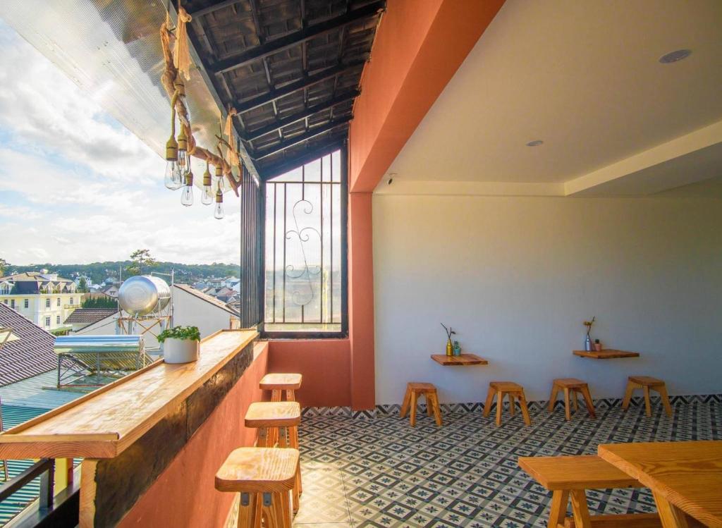 a bar with stools and a large window at Gin House Đà Lạt in Da Lat