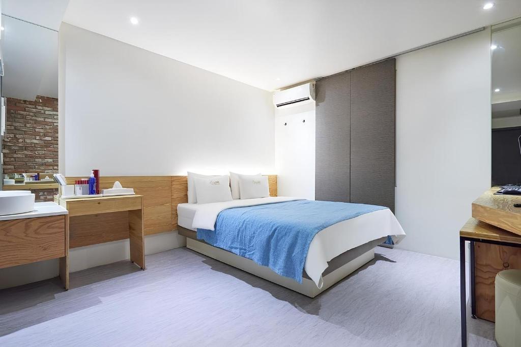 a bedroom with a bed and a desk and a sink at The Lime Hotel in Incheon