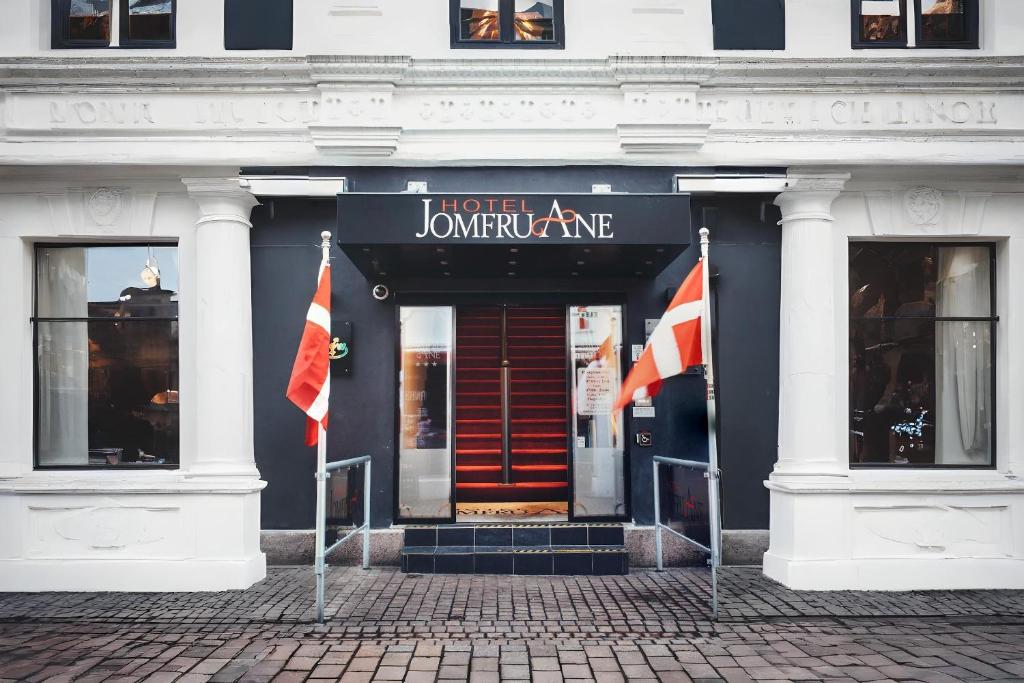 um edifício com duas bandeiras à frente em Dancenter Hotel Jomfru Ane em Aalborg