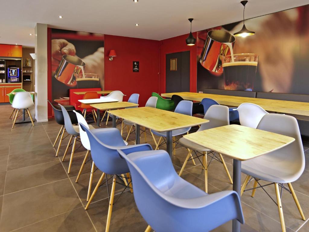 een restaurant met houten tafels en blauwe stoelen bij ibis Moulins in Moulins
