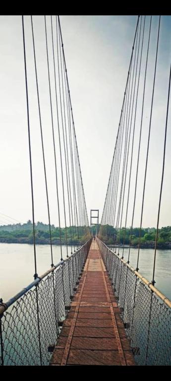 a bridge over a body of water at Sharvati Backwater Homestay in Haldipur