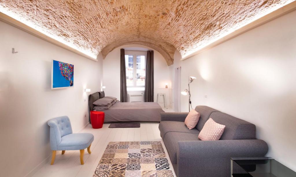 een woonkamer met een bank en een bed bij Bianca Dimora in Cagliari