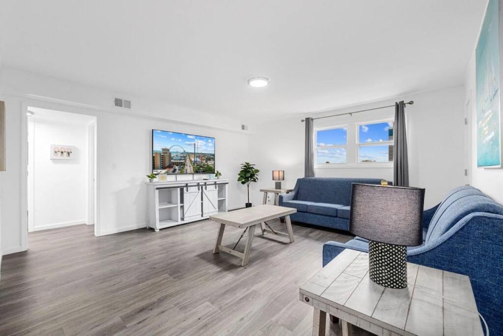een woonkamer met een blauwe bank en een tafel bij Oceanview Azul 2BR • Bright Top-Floor Condo in Myrtle Beach
