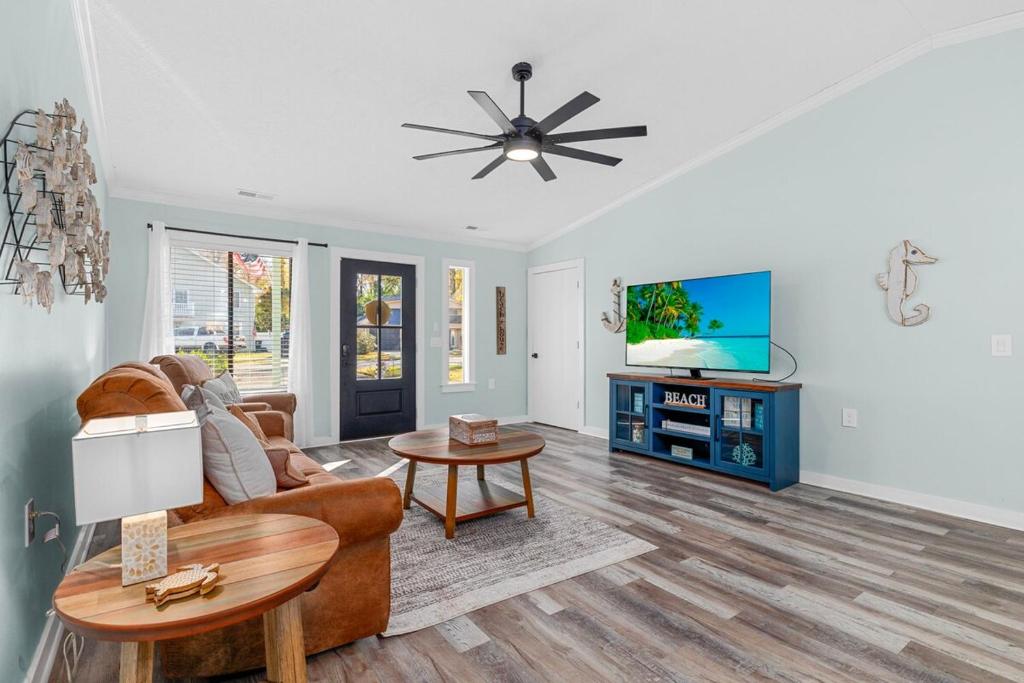a living room with a couch and a tv at Relax: Private Pool Grill Fire Pit in Myrtle Beach
