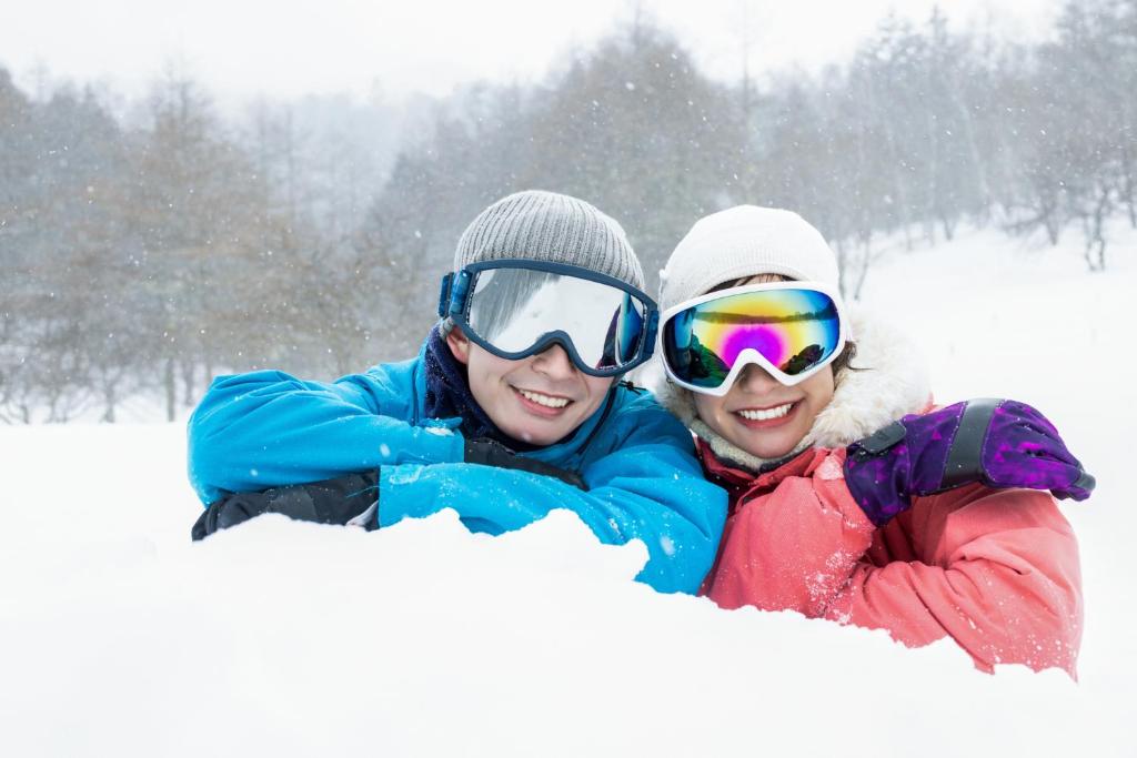 Due persone giacciono nella neve di Hotel SIMIZU a Tokamachi