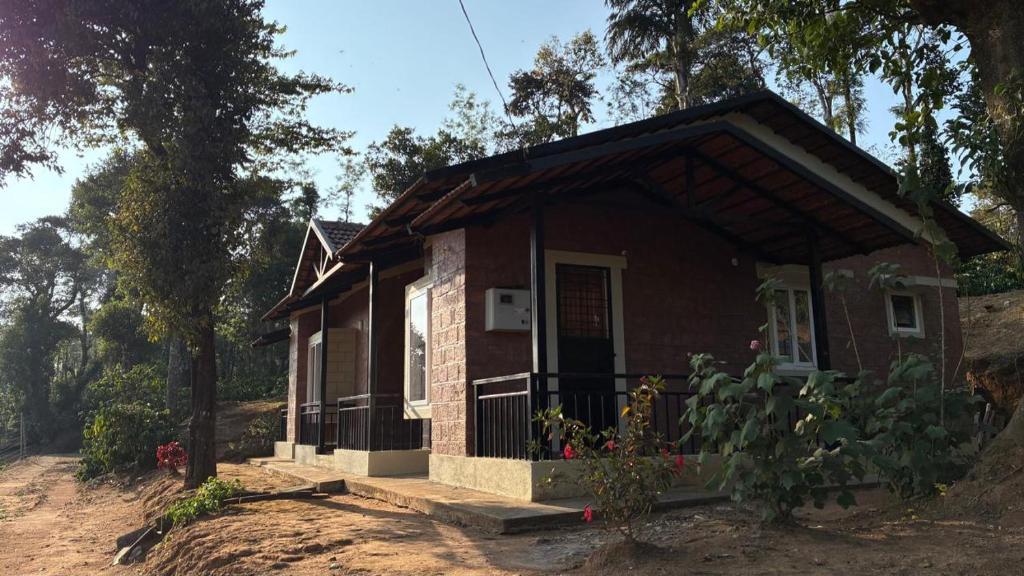 a small red brick house with a porch at Coffee By The Lake - B2 in Nidigere