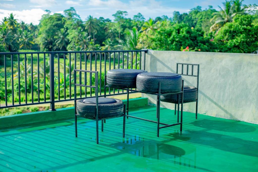 twee stoelen en een tafel op een balkon met bomen bij Galle Light Villa in Galle