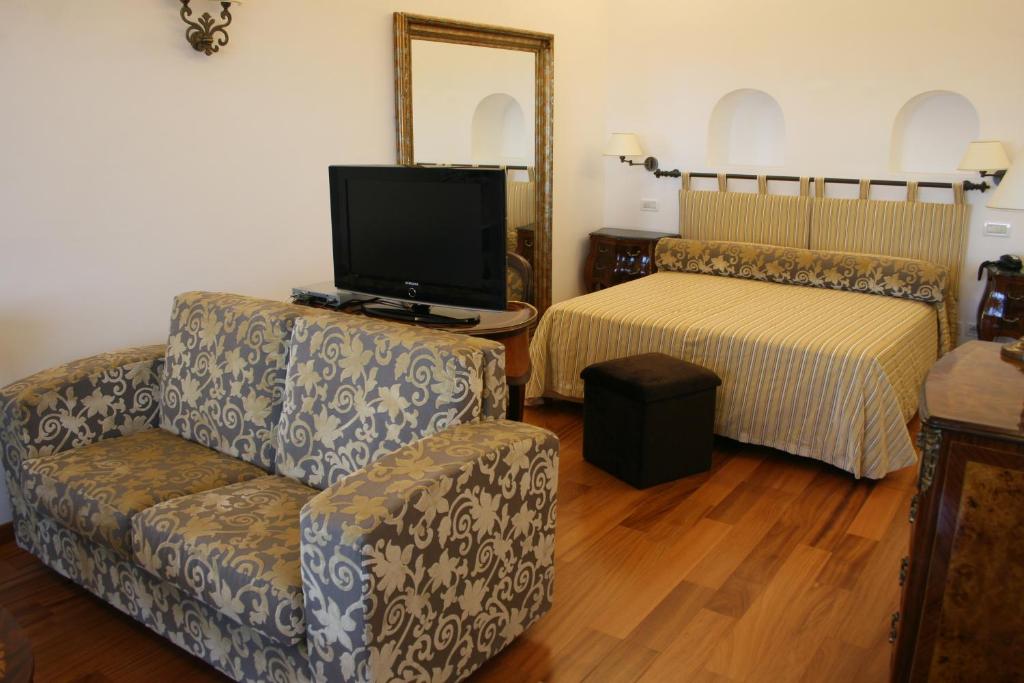 a living room with a couch and a tv and a bed at Diva La Canzone Del Mare in Capri