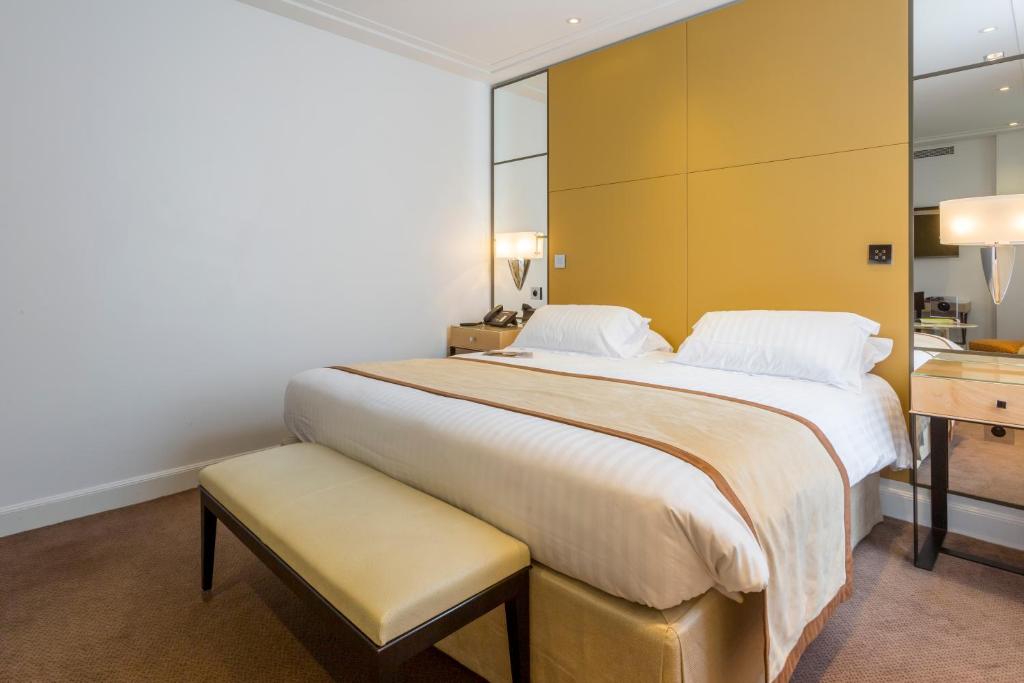 een slaapkamer met een groot bed met een gele muur bij Hôtel De Castiglione in Parijs