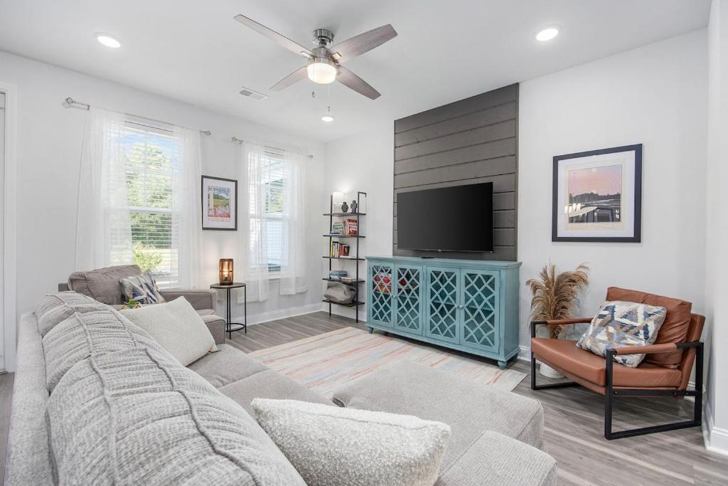 a living room with a couch and a flat screen tv at Birdie Bungalow- Games Beach Gear Sleeps 10 in Myrtle Beach