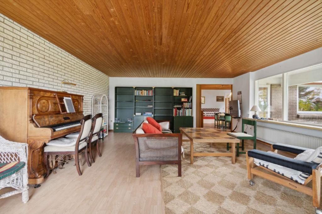 een woonkamer met een piano en een tafel bij Cozy Holiday Home In Thisted in Thisted