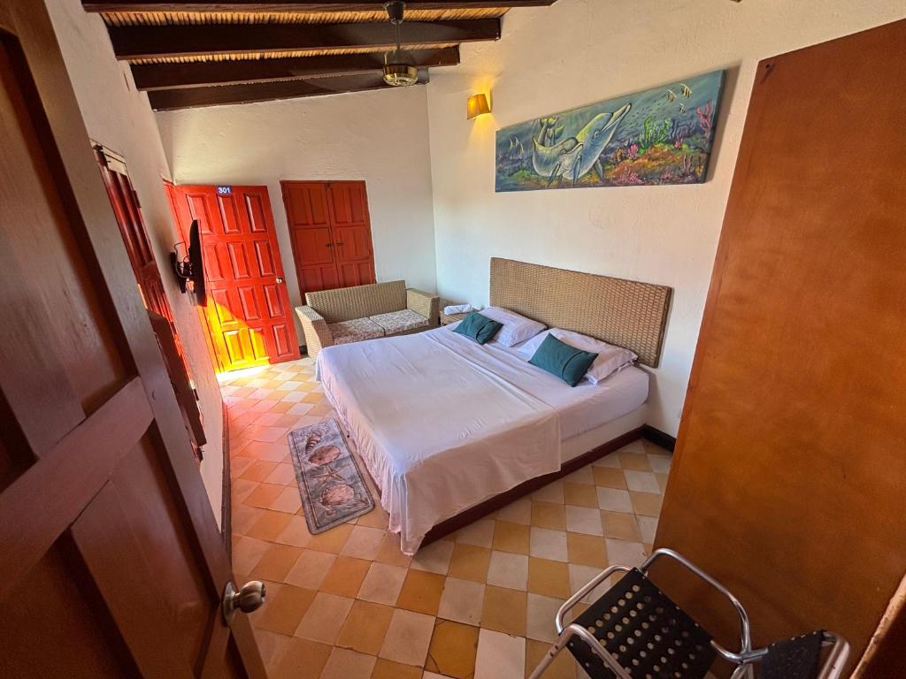 una camera da letto con un letto e una sedia in una stanza di Hotel Casa de Sarah a Santa Marta