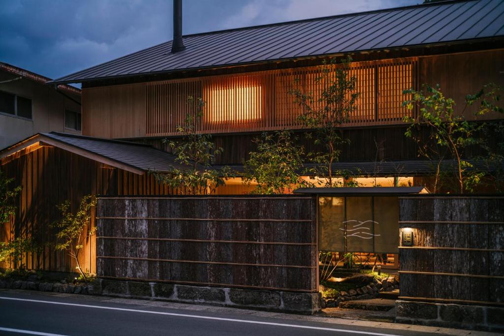 ein Haus mit schwarzem Dach und einer Straße in der Unterkunft Kasan in Kirishima