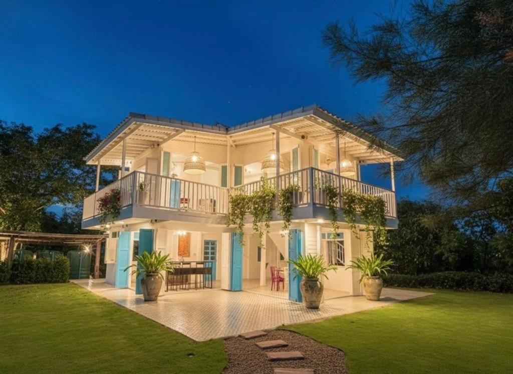 een groot wit huis met een balkon bij Today Sunset ที่พักวังน้ำเขียว in Ban Nong Chaeng