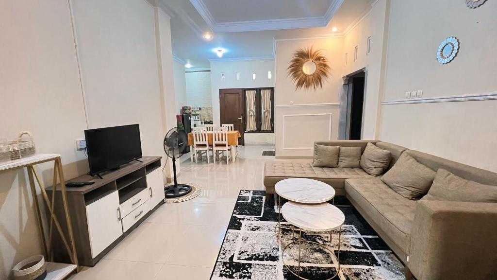 un soggiorno con un divano e una TV di Teem Living Jogja a Jejeran