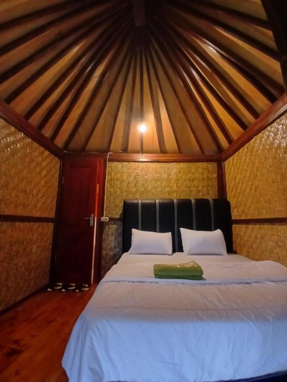 een slaapkamer met een bed in een yurt bij meta bungalow in Senaru