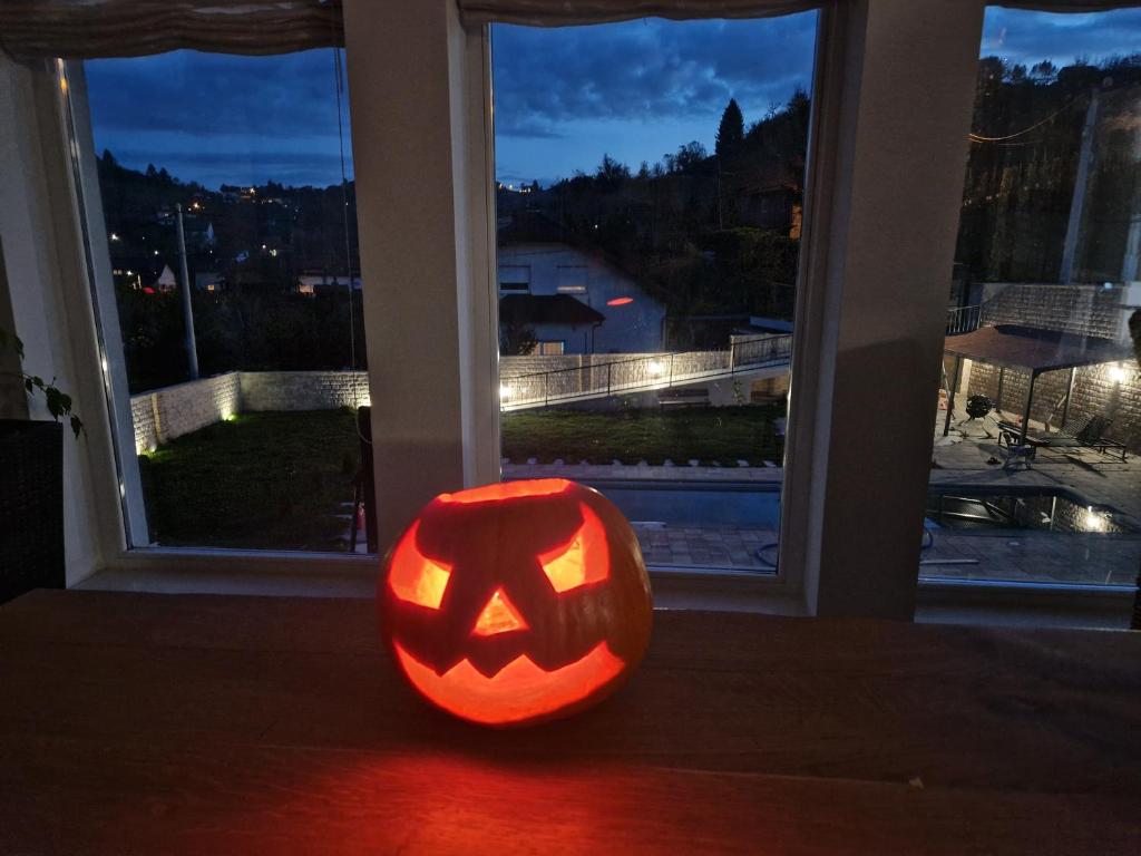 une citrouille d'Halloween posée sur une table devant une fenêtre dans l'établissement Villa Dubravka, à Kladje