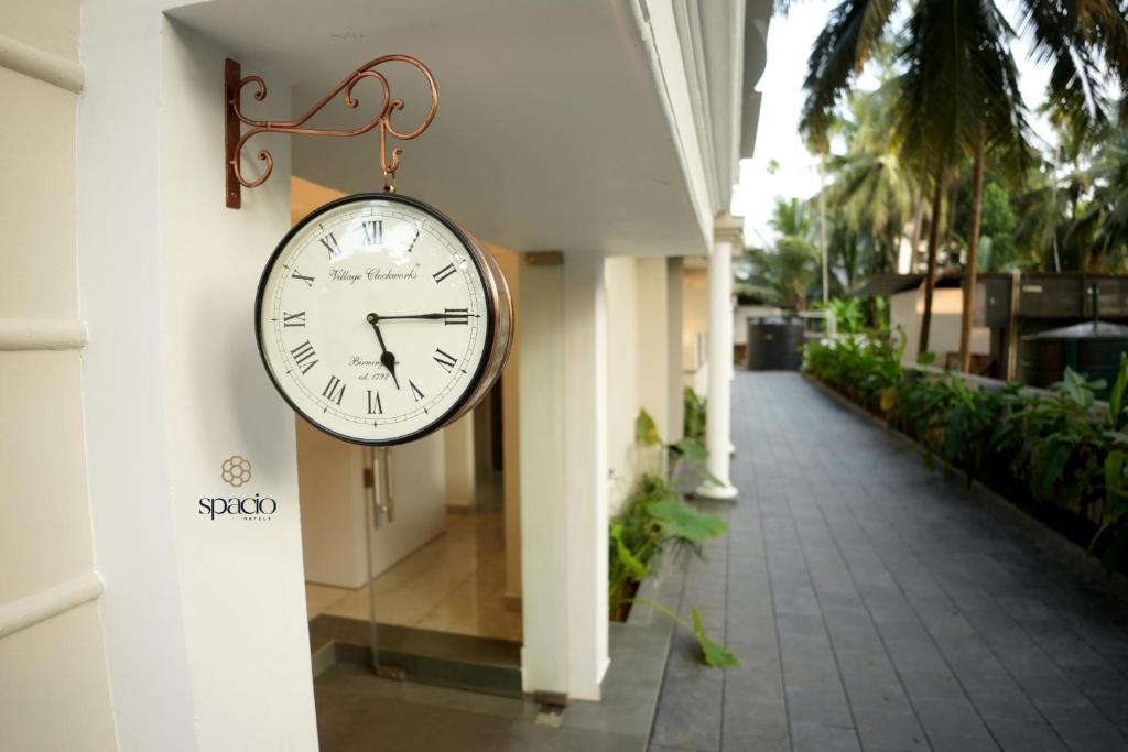 eine Uhr, die an der Seite eines Gebäudes hängt in der Unterkunft Hotel Spacio in Kozhikode