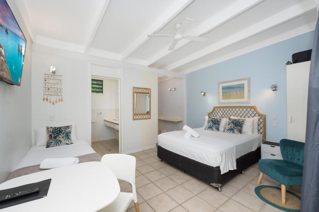 a bedroom with a bed and a desk and a chair at Unit 133 Amaroo Standard Twin Studio Apartment in Nelly Bay