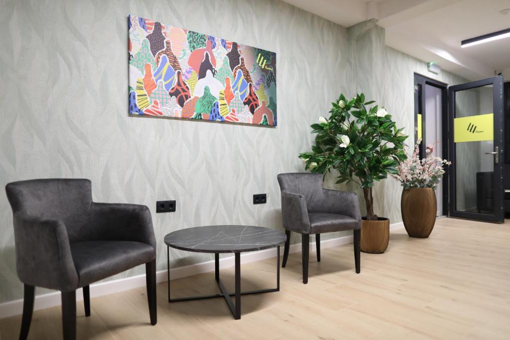 a waiting room with two chairs and a table at 44roomsMarghita in Marghita