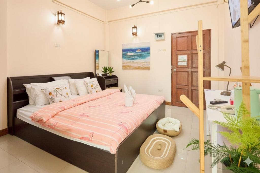 a bedroom with a large bed with a pink comforter at Ban Chang Pet-friendly Hotel by SCN in Ban Chang